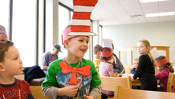 Five-year-old Axel Calderon smiles Thursday after finishing his hat and tie  to resemble The Cat in the Hat, a character based off the popular Dr. Seuss book "The Cat in the Hat." Children celebrated the March 2 birthday of Dr. Seuss a few days early at the Albert Lea Public Library Thursday. -- Sarah Stultz/Albert Lea Tribune
