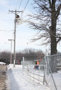 Alliant Energy crews work Thursday on utility poles on Richway Drive.