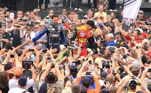 Drivers Jimmie Johnson, left, and Clint Bowyer high-five fans as they make their entrance onto the track Feb. 24 at the start of the Daytona 500. Johnson was the winner of the race. --Brandi Hagen/Albert Lea Tribun