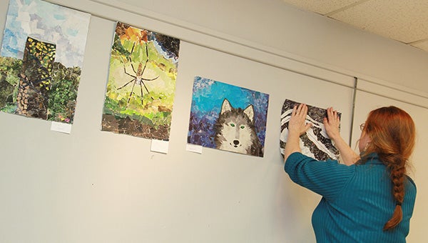 Albert Lea High School teacher Robin Brown, hangs up student collages in the Albert Lea Art Center earlier this week. The annual Elementary/Secondary Studen Art Exhibit starts with an open house from 1 to 3 p.m. Sunday. --Jason Schoonover/Albert Lea Tribune
