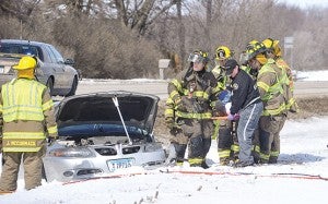 Austin firefighters and a Gold Cross paramedic carry the driver of a car involved in a two-vehicle accident north of Austin on Highway 218 North Saturday afternoon. The car collided head on with another vehicle and both the driver and a passenger of this vehicle were taken to the hospital by ambulance. --Eric Johnson/Albert Lea Tribune