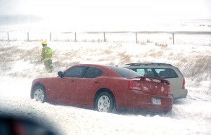 A firefighter checks on two vehicles that went into the northbound ditch on Interstate 35 Monday between Albert Lea and Clarks Grove. -- Brandi Hagen/Albert Lea Tribune