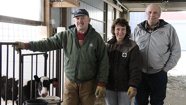 John, Alana and Dick Miller pose for a photo by one of their calves at the Miller dairy operation just north of Oakland. The Millers won the Farm Family of the Year Award today from the Albert Lea-Freeborn County Chamber of Commerce. --Kelli Lageson/Albert Lea Tribune