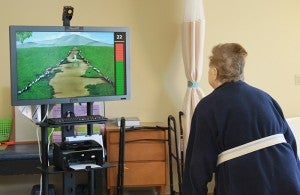The rehabilitaion unit is similar to a Kinect gaming system and helps residents work on their rehab in a fun way. In this exercise, she moves around to pick flowers. 