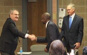 Adenuga Atewologun, recently appointed president of Riverland Community College, shakes hands with Minnesota State Colleges and Universities System Chancellor Steven Rosenstone while MnSCU trustee Duane Benson looks on. Atewologun starts July 1.