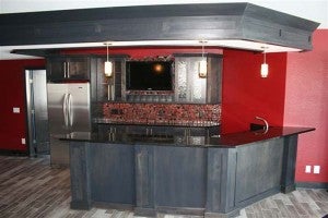 RWP designed this bar in a new home recently. It has the dropped soffit area, as well as charcoal wood, which is a popular color. The bar also features textured glass cabinet doors and a tile backsplash. -- Submitted