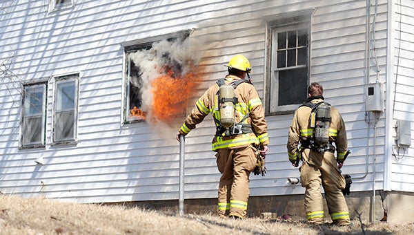 Doug Johnson and Trevor DeRaad on Thursday watch a fire blast out a window on a house at 816 W. William St. The fire was part of a controlled burn for firefighters who are taking the Minnesota State Fire Marshal Fire Investigation Class.  --Brandi Hagen/Albert Lea Tribune
