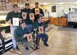 Morgan’s Meat Market employees display a series of awards the company received at the annual Minnesota Association of Meat Processors banquet, including the Best in Show for their wild rice and cranberry summer sausage. Clockwise from bottom right are Patti Schlaak, Roger Yess, Levi Arnold, Kelby Johnson and Dean Morgan. 