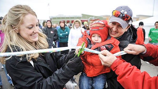 Luke Gooden, 2 1/2, cuts the ribbon with the help of his parents Megan and Brady, of Alden, to kick off the 2013 March for Babies Saturday morning. -- Eric Johnson/Albert Lea Tribune