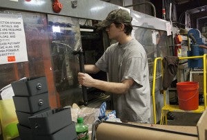 Tyler Kvenvold opens the door to a piece of machinery Tuesday at Interstate Molding & Manufacturing in Albert Lea.
