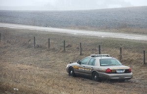 A Freeborn County sheriff's deputy waits in his patrol car after it slid into the ditch of Interstate 90 west of Albert Lea.