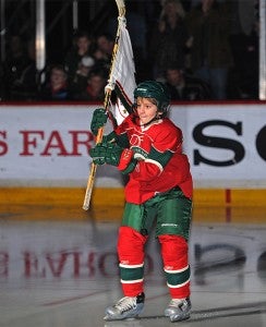 Bradley Horecka, a hockey player for Albert Lea’s B Squad Red Squirts waves the flag at an NHL game. The Minnesota Wild hosted the St. Louis Blues. — Submitted