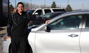 George Gonzalez, Nissan/VW new car manager at Dave Syverson Auto Center, poses next to his favorite car:  a 2013 Nissan Altima. Gonzalez said he likes the new look of the car.