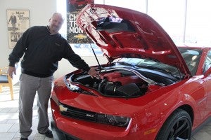 Mark Kness, sales associate at Vern Eide Chevrolet, takes a look under the hood of his favorite car at the dealership: A Chevy Camaro ZL1. He likes that it has the old ’60s muscle car look. 