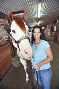 Jodie Distad, owner of Broadway Farms south of Albert Lea, poses with Oh Y Not. Distad trains horses for others as well as breeds horses as well as riders.
