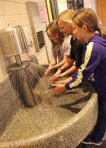 Hollandale Christian School third-graders, from left, Marlea Emberson, Gabrielle Ladlie and Kendra Smeby wash their hands before lunch. Principal Lisa Vos said she’d like to keep the basin sinks that are located outside the bathrooms because it’s convenient for children to walk by and wash their hands before lunch. --Kelli Lageson/Albert Lea Tribune