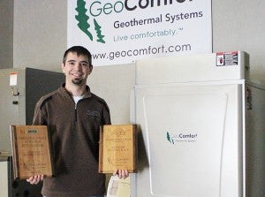 Mark Johnson, project engineer at Johnson Heating & Air Conditioning in Albert Lea, holds two awards the company won on April 23. --Kelli Lageson/Albert Lea Tribune
