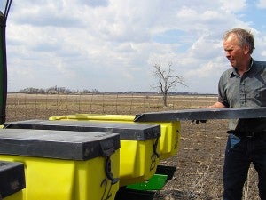 Alan Roelofs replaces the lid on a seed hopper on his 24-row corn planter. Like most Minnesota farmers, Roelofs got a late start this year on planting corn.