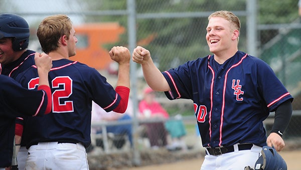 Lucas George, right, a senior from United South Central, is congratulated by senior catcher Trey Allis after scoring a run in the top of the second inning. — Micah Bader/Albert Lea Tribune 