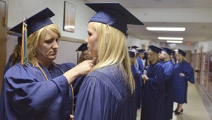 Laurie Stevens adjusts Sara Alms' robes before walking in for Riverland Community College's 2013 commencement Friday night in Knowlton Auditorium. -- Eric Johnson/Albert Lea Tribune