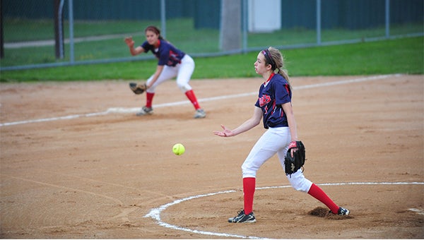 Albert Lea pitcher Haley Harms throws a pitch, as Caycee Gilbertson gets ready on third base in a 5-2 loss to Winona Friday in the second round of the consolation bracket of the Section 1AAA tournament. — Micah Bader/Albert Lea Tribune