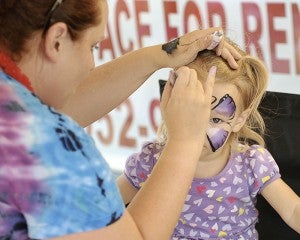 Then 3-year-old Clara McIntyre holds her head still for artist Brandy Wilker during the first Tuesday on Main last July. --Eric Johnson/Albert Lea Tribue