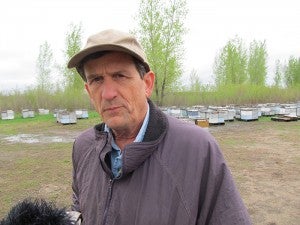 Beekeeper Steve Ellis stands in a bee yard where about 1,300 hives wait to be placed in fields for summer honey production. Thousands of bees recently died, and Ellis blames neonicotinoid pesticides. Ellis expects his hives to be much less productive this year.