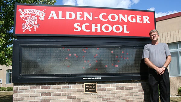 Alden-Conger’s new principal Brian Shanks stands next to the school sign. --Kelli Lageson/Albert Lea Tribune