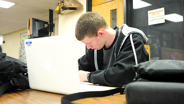 Fifteen-year-old Scott Hengesteg listens to music on his laptop in the library at Northwood-Kensett High School while working on homework.  --Brandi Hagen/Albert Lea Tribune
