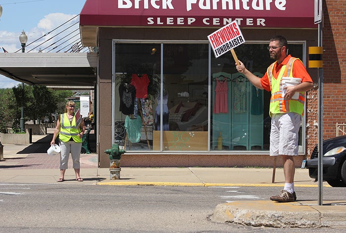 Brad Skinness and Connie Kaupa stand at the intersection of Broadway and Main Street Friday afternoon collecting money as part of the annual fireworks fundraiser. -- Sarah Stultz/Albert Lea Tribune