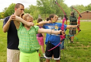 Skylar Voight, 11, tries her hand at archery Saturday with the help of Mike Juntunen with Albert Lea Community Education. Families could enjoy free archery, kayaking, canoeing and other activities for free Saturday during Open Streets Albert Lea. 