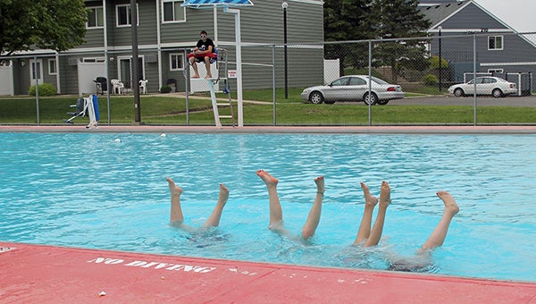 A group of friends do hand stands in the pool on Monday. There were only about 10 kids in attendance. --Erin Murtaugh/Albert Lea Tribune