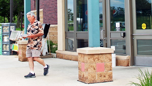 Larry Biard, of Texas, walks out of the welcome center with maps. Biard and his wife stopped at the welcome center while on their way to see their son in Winona. --Erin Murtaugh/Albert Lea Tribune