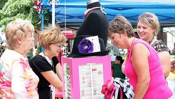 Laura Lunde, right, talks with customers at her booth at Wind Down Wednesday. Lunde had jewelry for sale.  --Erin Murtaugh/Albert Lea Tribune