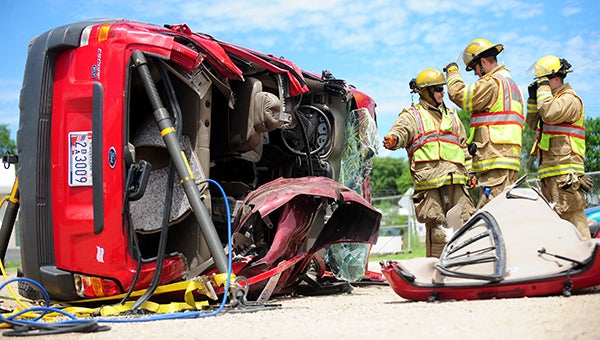Firefighters Trevor DeRaad, Kurt Wallace and Jordan DeVries discuss the stabilization of a flipped Ford Escape during an extrication training Thursday in Albert Lea at Allen's Tow 'N Travel. The firefighters used the Escape to practice multiple rescue scenarios. -- Brandi Hagen/Albert Lea Tribune