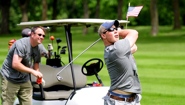 Justin Holland swings a club on the fairway Saturday during the Corey Goodnature Golf Classic. Holland has participated in the event for five years. — Micah Bader/Albert Lea Tribune    