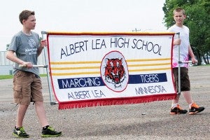 Dane Brownlow, left, and Tanner Darbo, right, carry the Albert Lea High School marching band banner. The band’s first performance is the Third of July Parade in Albert Lea. 
