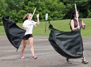 Madi Lindely, left, and Maria Silva, right, practice the routine for color guard. This is the first year the marching band had a color guard in since becoming only a drumline. 