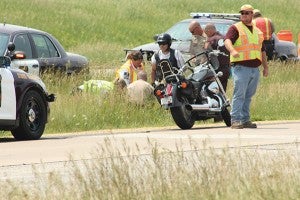 Mower County Deputies, State Patrol and Gold Cross EMTs tend to a downed motorcyclist who was injured in a crash Monday afternoon on Interstate 90 near the 28th Street overpass in Austin. --Matt Peterson/Albert Lea Tribune