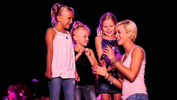 Kellie Pickler made the night of three cousins from Blue Earth at Tuesday’s Grandstand show. Pickler brought Rylan Storbeck, 7, left, Katelyn Storbeck, 5, and Payten Gudahl, 7, on stage to sing “Best Days of Your Life” with her near the end of the show. --Brandi Hagen/Albert Lea Tribune