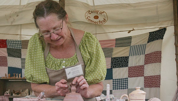 Reggie Delarm makes miniature pottery pieces in her tent at the Freeborn County Fair. She will be there all week selling her pieces and telling the history of pottery in the United States. --Kelli Lageson/Albert Lea Tribune