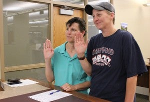 Virginia Chadbourne, left, and Della Hill raise their hands while applying for a marriage license Thursday at the Freeborn County Recorder’s Office. Chadbourne and Hill were the first same-sex couple in Freeborn County to apply. 
