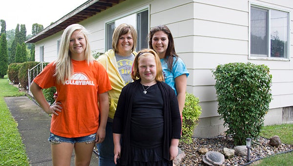 Patti Groe, back middle, stands with her daughters from left, Emily Benson, Maci Benson and Madison Michaelson, in front of their home on Frank Hall Drive. Groe’s family is one of four that will see renovations during this year’s Rocking the Block and other Shinefest service projects. --Sarah Stultz/Albert Lea Tribune