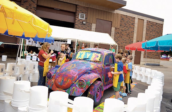 Kids crowd around a VW Bug for a chance to put their artistic touch on it during last year's Austin ArtWorks Art Festival at the downtown Austin Utilites plant. Eric Johnson/Albert Lea Tribune
