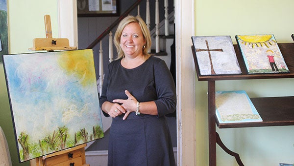 Kelly Gau stands with some of her art at her studio in her home last week. --Erin Murtaugh/Albert Lea Tribune