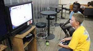 Michael Caballero (in yellow), 10, and Chay Guen, 11, play the “NHL 13” video game from Electronic Arts on Tuesday afternoon at The Rock. --TIm Engstrom/Albert Lea Tribune