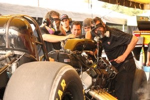 Crew members wear masks to protect themselves from nitro as they work on a car at Brainerd Interational Raceway last weekend.