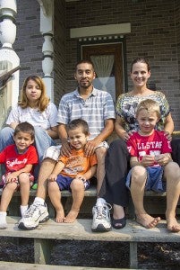 Lennie Aguilera and his fiancee Julie Cincoski sit on their front steps on Wednesday with four of their six children. -- Sarah Stultz/Albert Lea Tribune