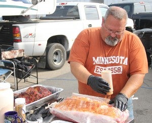 Rich Jensen uses his dry rub on racks of ribs before they are placed in a smoker he and his brother made out of a large LP tank. The brothers were competing at this weekend’s Big Island Bar-B-Que festival. --Kelli Lageson/Albert Lea Tribune