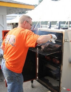 Brothers Bruce, in front, and Rich check on their racks of ribs Saturday at the 2013 Big Island Bar-B-Que event at the Freeborn County Fairgrounds. The brothers operate under the name Smokin Bros BBQ and have catered all kinds of events.